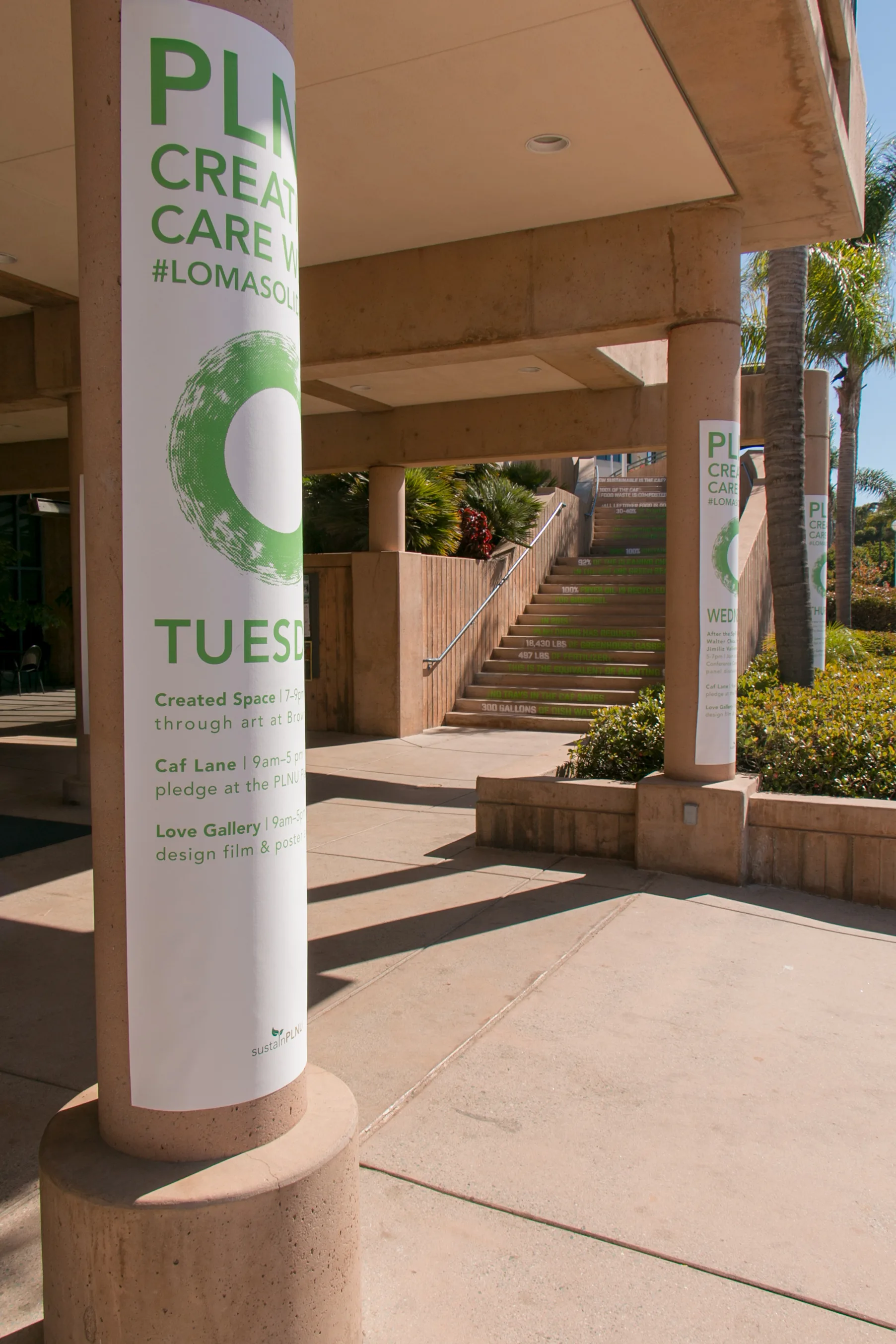 Campus pillar wrapped with a Creation Care Week schedule banner listing Tuesday events, staircase visible behind