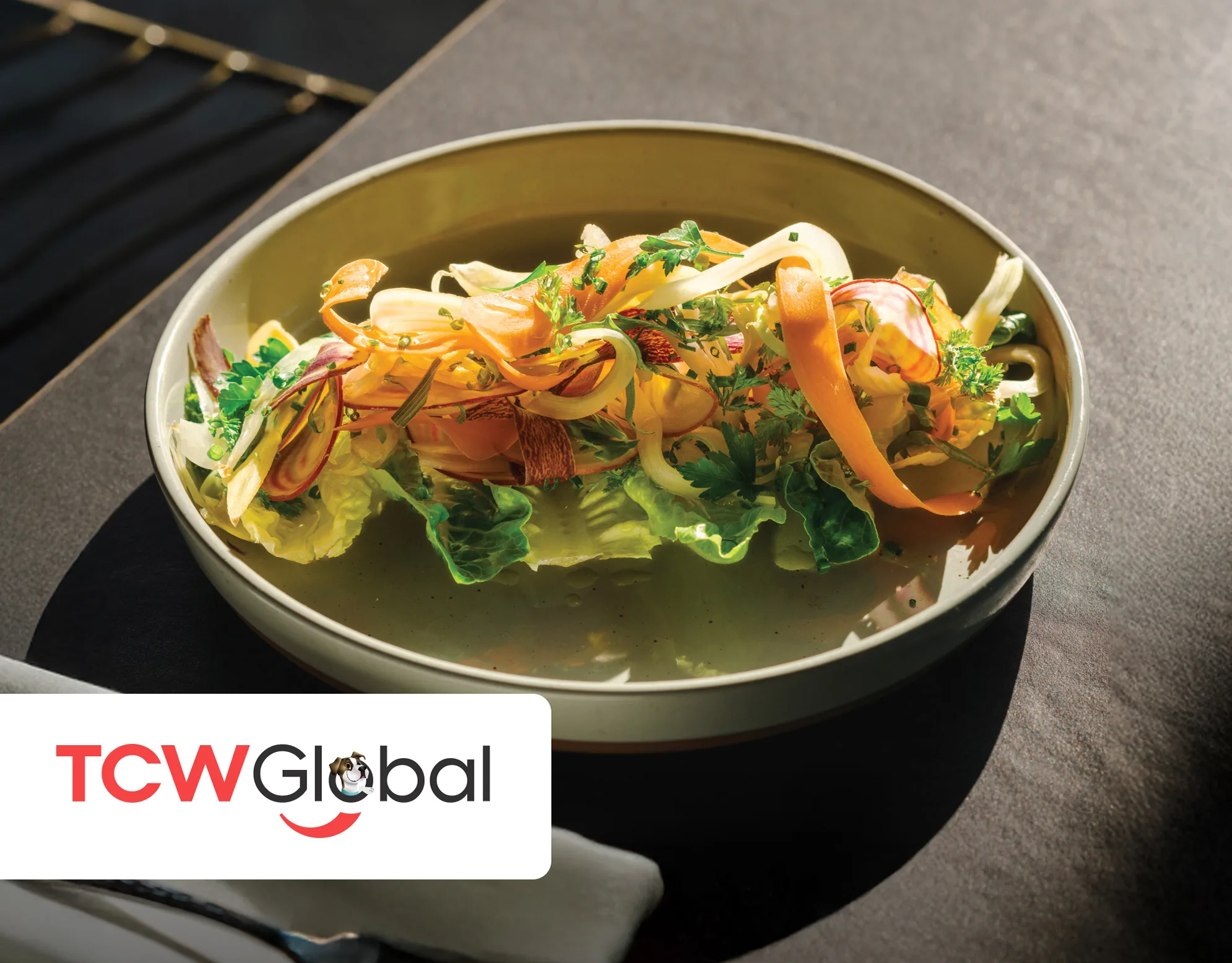 BoujieMana cover: overhead shot of a gourmet plated dish with citrus, herbs, and greens in a shallow broth
