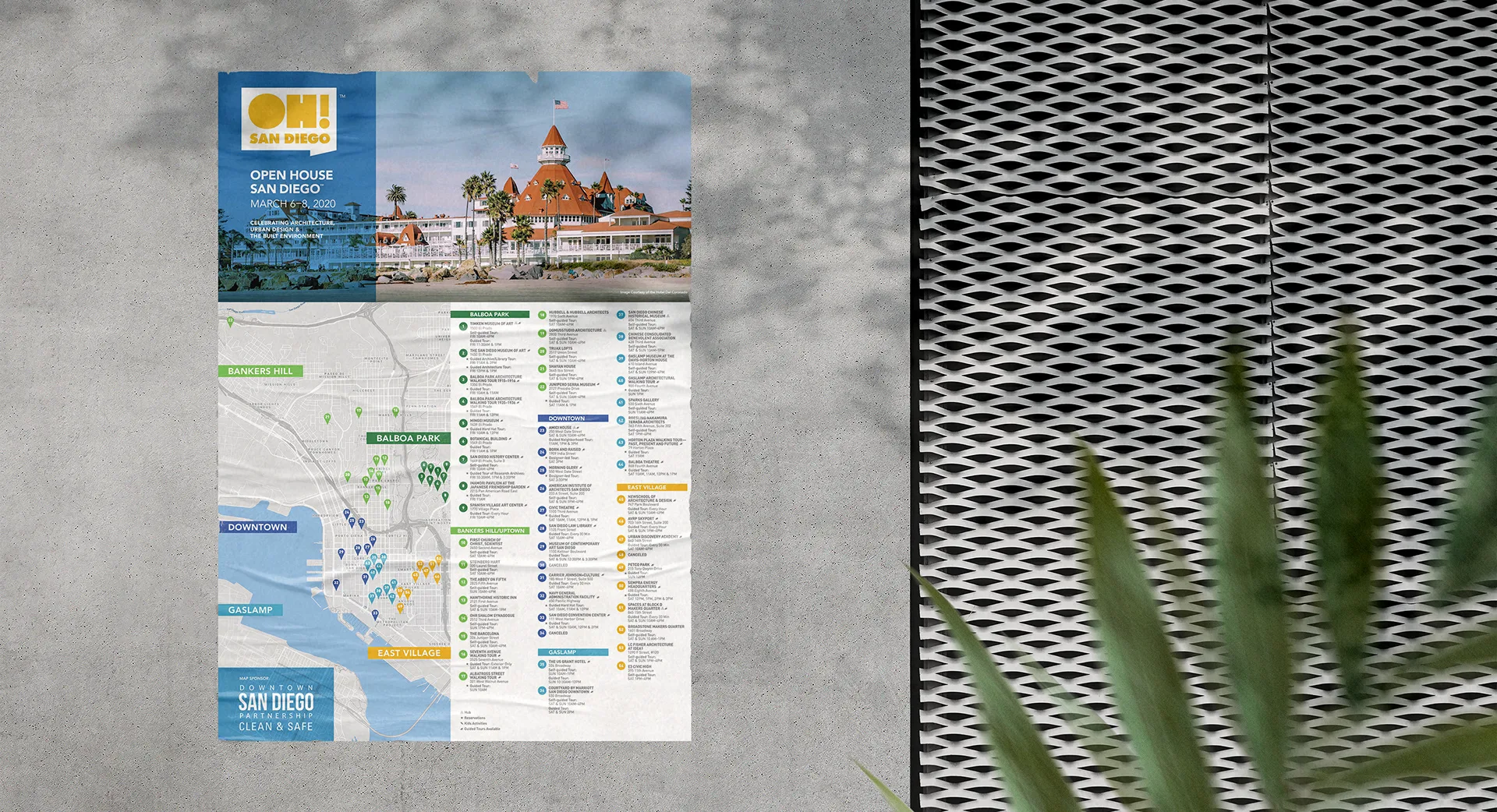OH! San Diego neighborhood map poster laid on concrete beside a decorative metal screen and a plant