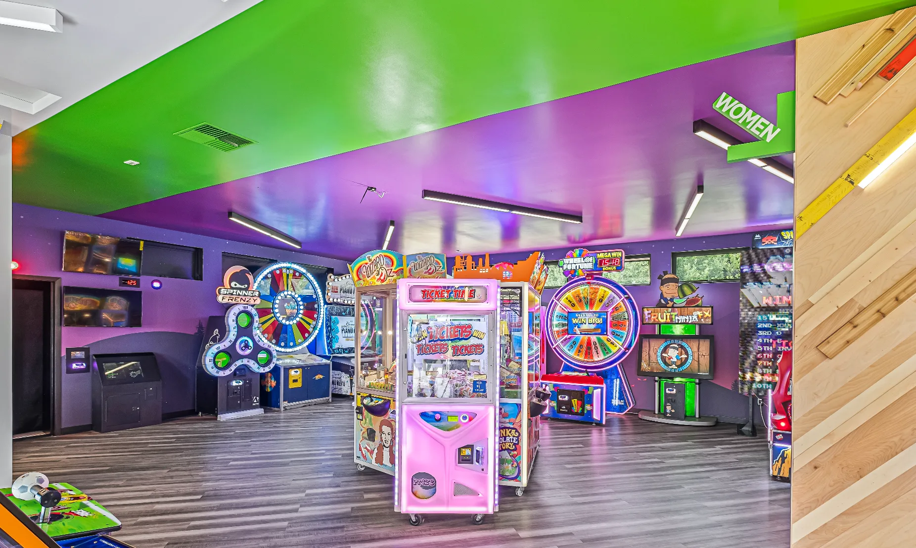 Pacific Paradise arcade floor with prize wheel games, redemption machines, and colorful cabinet lighting