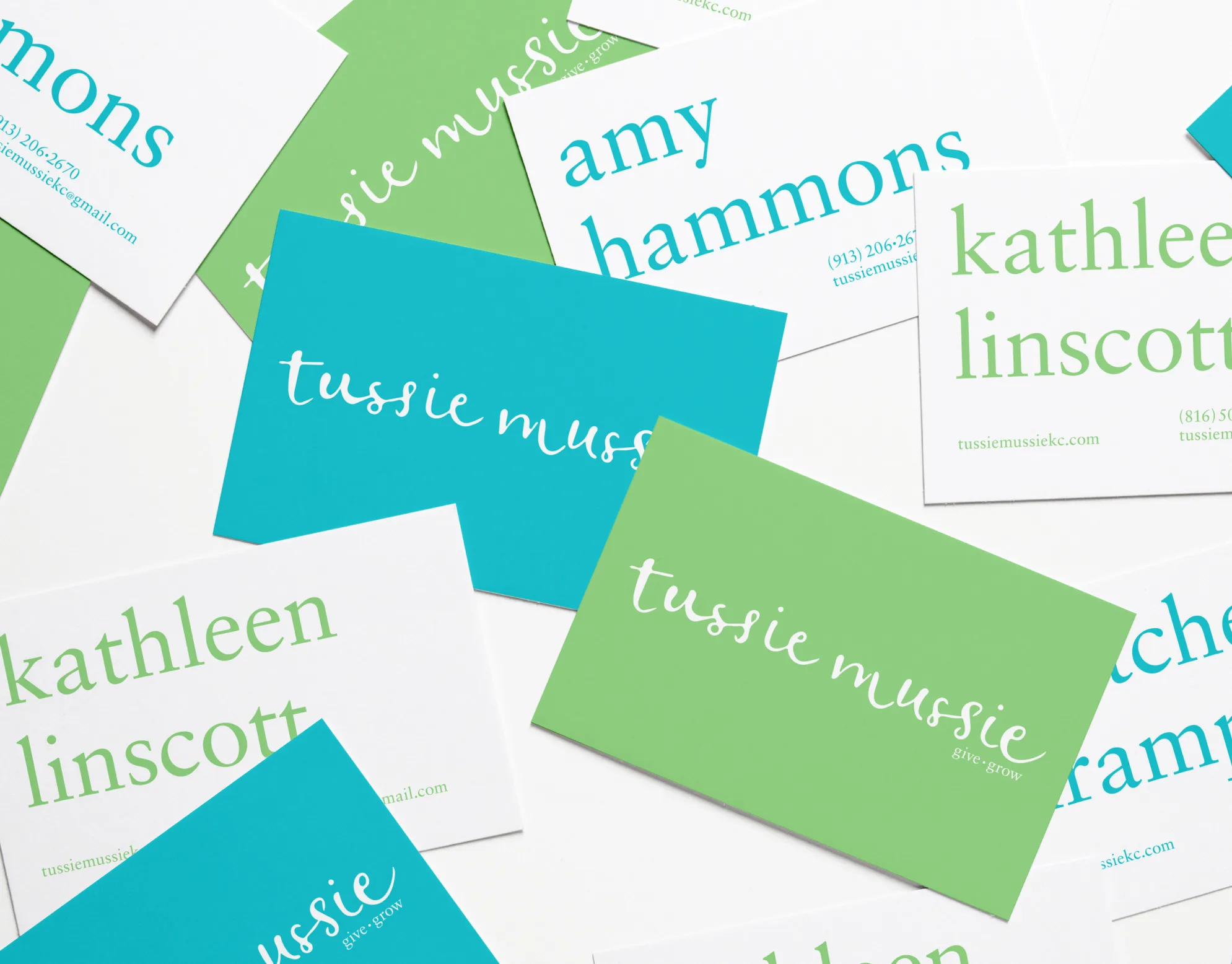 Tussie Mussie cover: scattered teal, green, and white business cards printed with the tussie mussie logo and staff names
