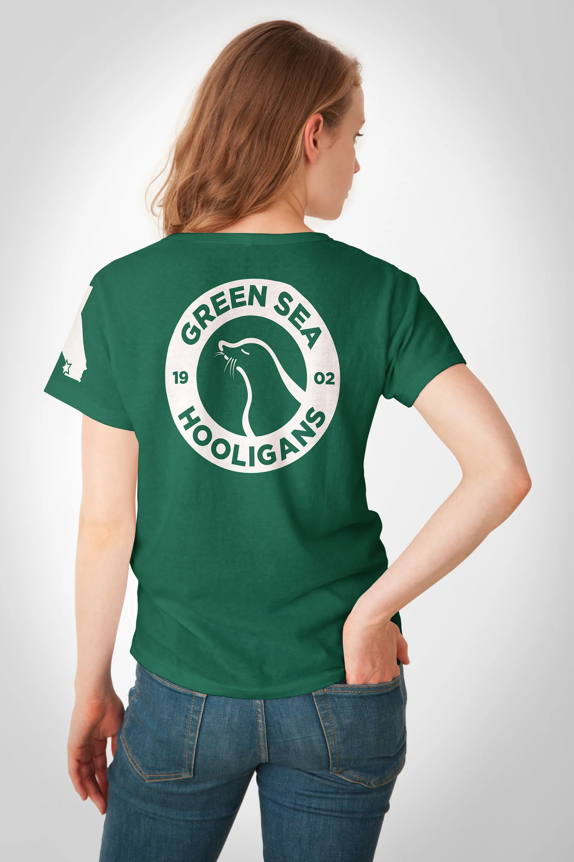 Back view of a model wearing a green t-shirt printed with the Green Sea Hooligans sea lion logo and 1902